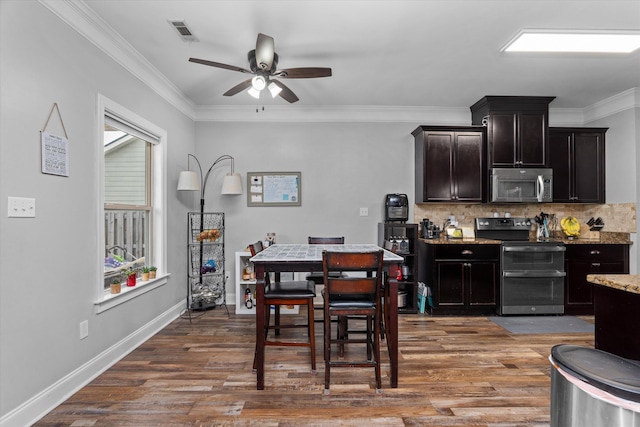 kitchen with visible vents, a ceiling fan, wood finished floors, stainless steel appliances, and backsplash