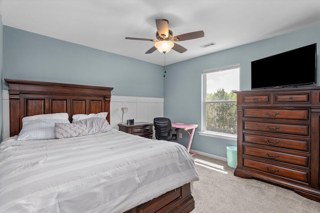 bedroom featuring visible vents, baseboards, a ceiling fan, and light carpet