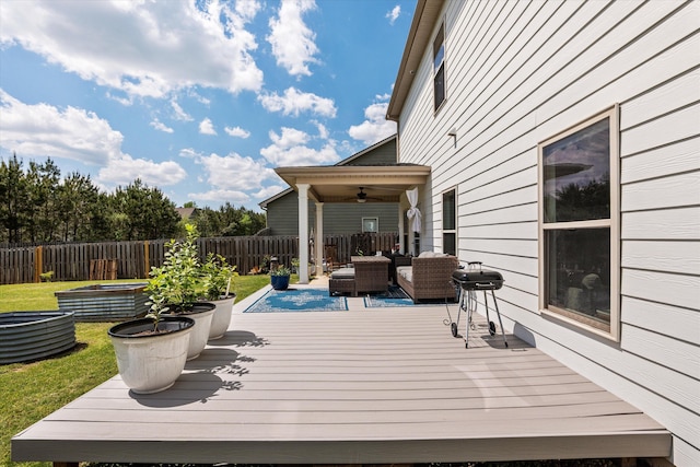 wooden deck featuring an outdoor hangout area, a ceiling fan, a lawn, grilling area, and fence