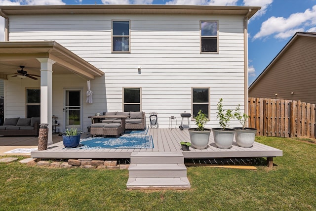 rear view of property featuring outdoor lounge area, a wooden deck, fence, and a lawn
