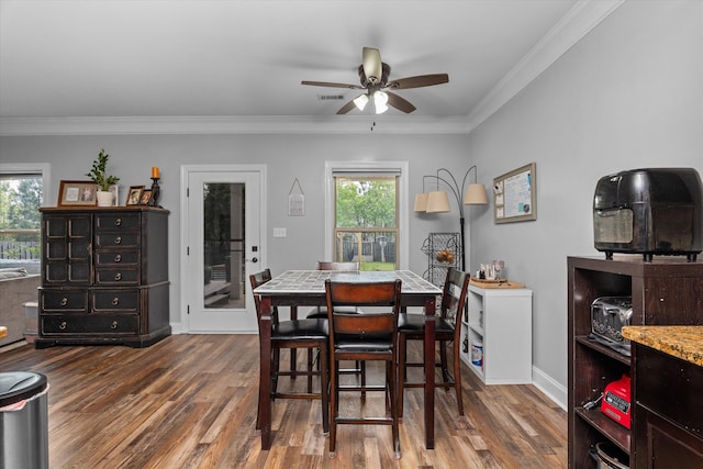 dining space featuring ceiling fan, visible vents, crown molding, and wood finished floors