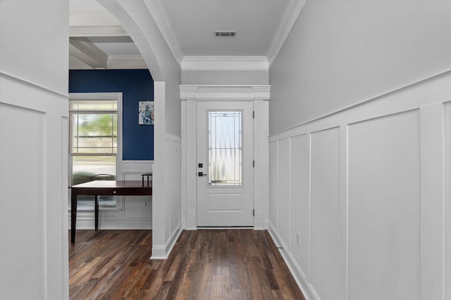 doorway to outside featuring visible vents, a decorative wall, ornamental molding, dark wood-style flooring, and a wainscoted wall