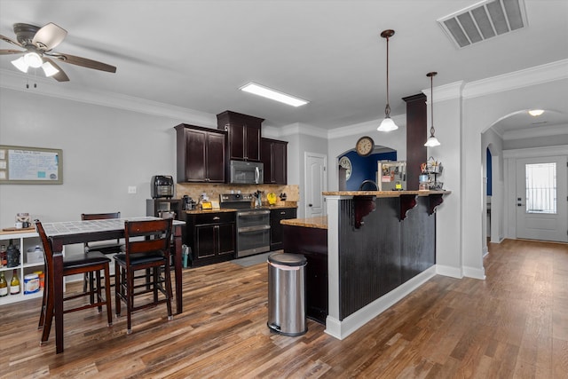 kitchen featuring arched walkways, a ceiling fan, visible vents, appliances with stainless steel finishes, and dark wood-style floors