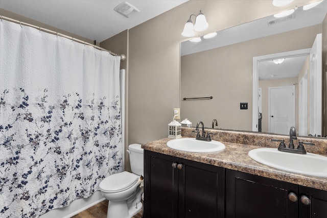 bathroom featuring a sink, visible vents, toilet, and wood finished floors