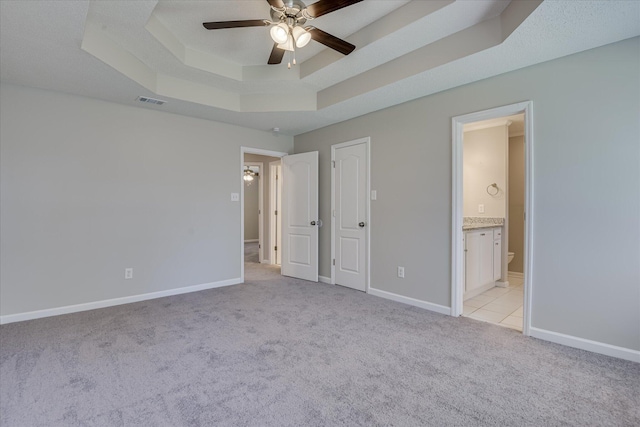 3650 Crawfordville Dr, Augusta, GA 30909 - unfurnished bedroom featuring light carpet, a tray ceiling, ensuite bath, and ceiling fan