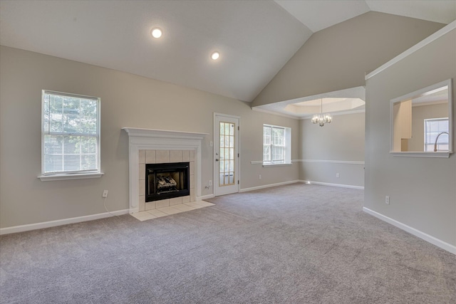 3650 Crawfordville Dr, Augusta, GA 30909 - unfurnished living room with a chandelier, a tile fireplace, vaulted ceiling, carpet flooring, and healthy amount of natural light