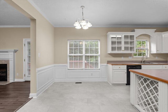 1094 Hampstead Pl, Martinez, GA 30907 - kitchen featuring a chandelier, white cabinets, dishwasher, crown molding, and a tile fireplace