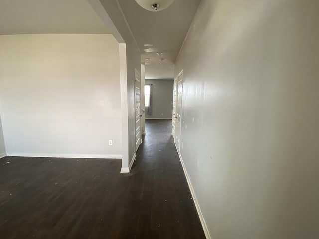 hallway with dark wood-style floors and baseboards