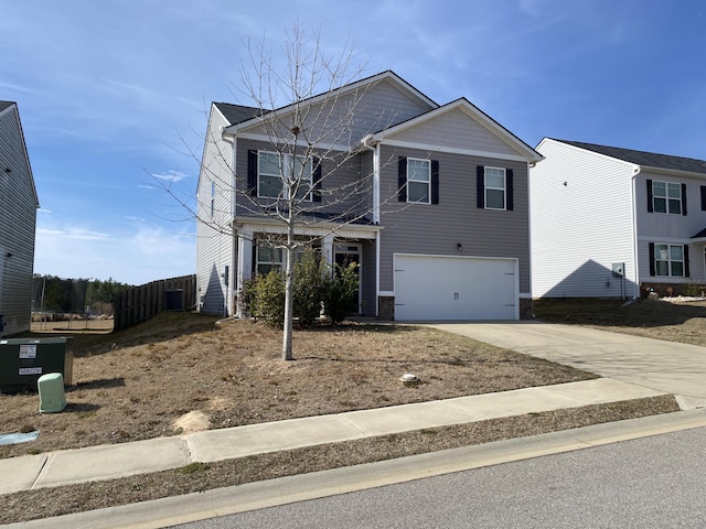 traditional home with concrete driveway, an attached garage, and fence