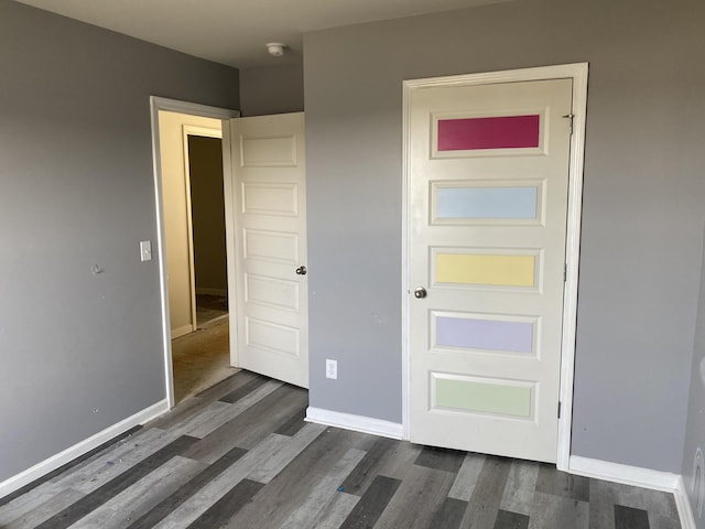 unfurnished bedroom featuring dark wood finished floors and baseboards