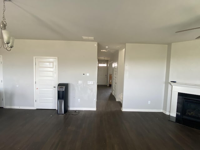 unfurnished living room featuring baseboards, visible vents, a ceiling fan, wood finished floors, and a fireplace