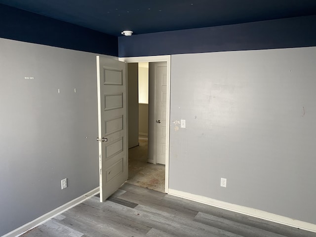 unfurnished bedroom with wood finished floors and baseboards