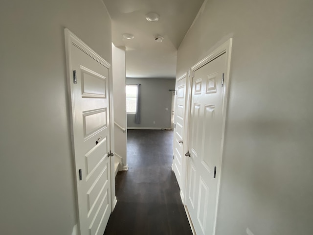 hall with dark wood finished floors and baseboards