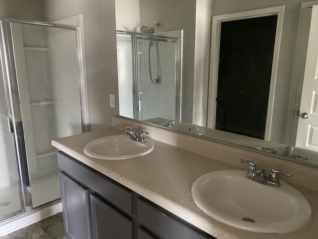 full bath with a stall shower, a sink, and double vanity