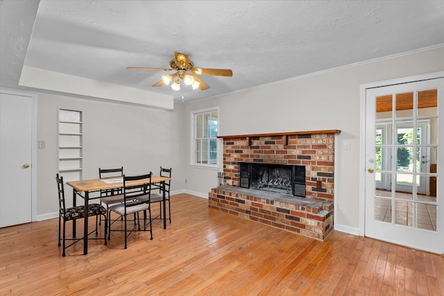 172 Creek View Ct, Martinez, GA 30907 - dining room featuring a brick fireplace, hardwood / wood-style floors, healthy amount of natural light, a ceiling fan, and crown molding