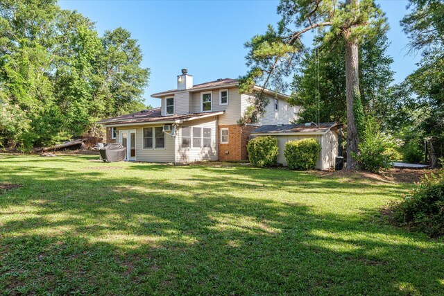 172 Creek View Ct, Martinez, GA 30907 - back of property with a storage shed, a chimney, a yard, brick siding, and a sunroom