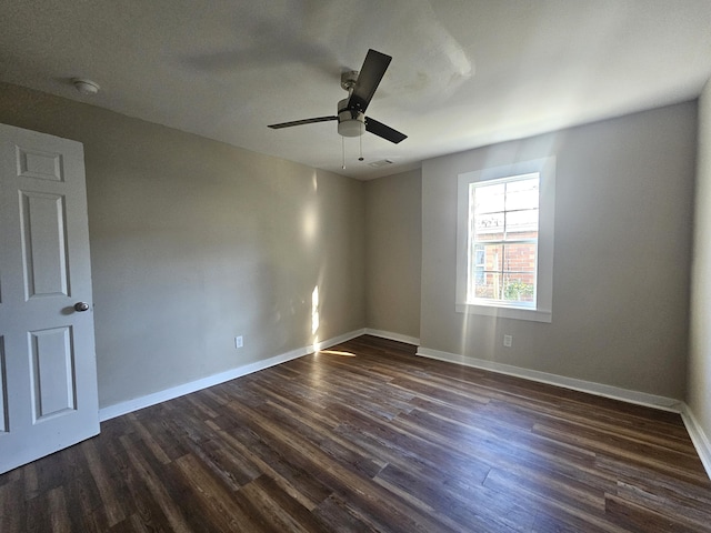 empty room with dark wood-type flooring and ceiling fan