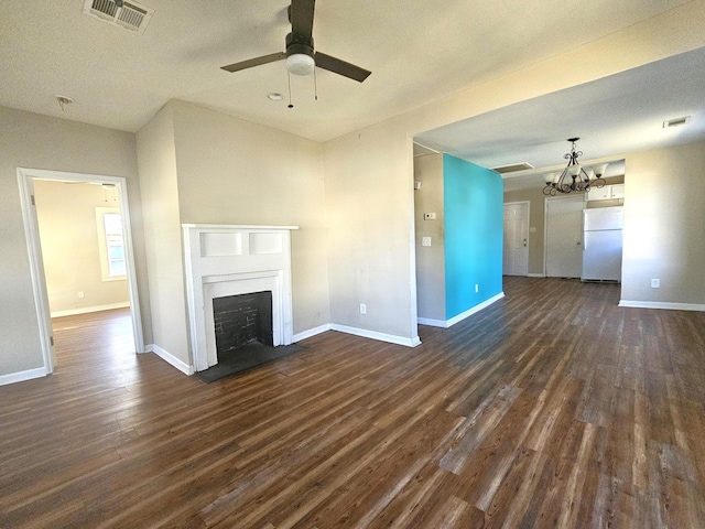 unfurnished living room featuring dark hardwood / wood-style flooring and ceiling fan with notable chandelier