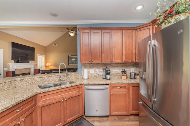 821 Wickham Dr, Graniteville, SC 29829 - kitchen featuring appliances with stainless steel finishes, a sink, lofted ceiling, light stone countertops, and brown cabinets
