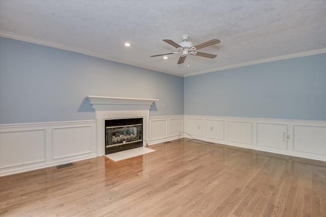 786 Springbrook Ln, Evans, GA 30809 - unfurnished living room featuring a ceiling fan, a fireplace with flush hearth, a decorative wall, wood finished floors, and ornamental molding