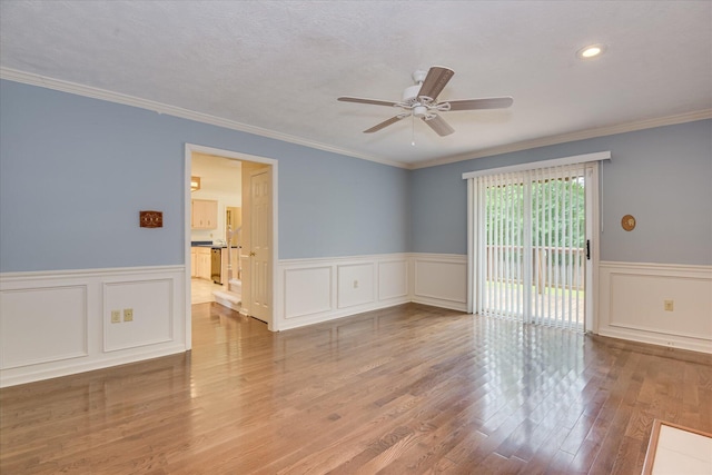 786 Springbrook Ln, Evans, GA 30809 - unfurnished room featuring a ceiling fan, a wainscoted wall, wood finished floors, crown molding, and a decorative wall