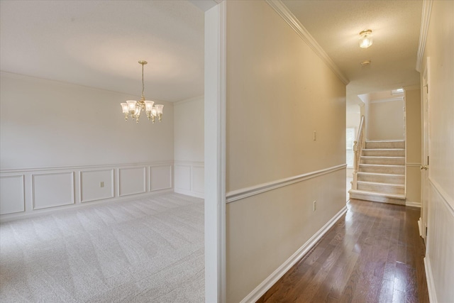 786 Springbrook Ln, Evans, GA 30809 - hallway featuring crown molding, a chandelier, wood finished floors, stairway, and a wainscoted wall