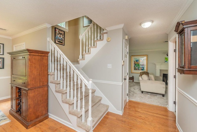 345 Old Salem Way, Martinez, GA 30907 - stairway featuring a textured ceiling, wood finished floors, crown molding, and a fireplace