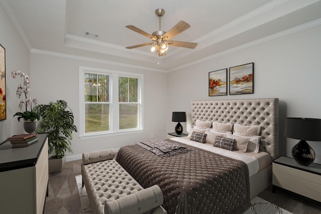 carpeted bedroom with baseboards, visible vents, ceiling fan, ornamental molding, and a raised ceiling