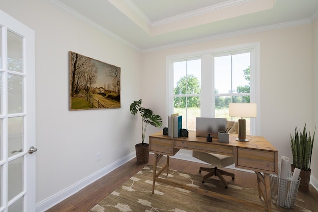 office area with a tray ceiling, wood finished floors, baseboards, and ornamental molding