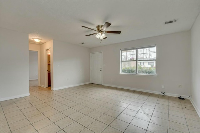 tiled empty room featuring ceiling fan