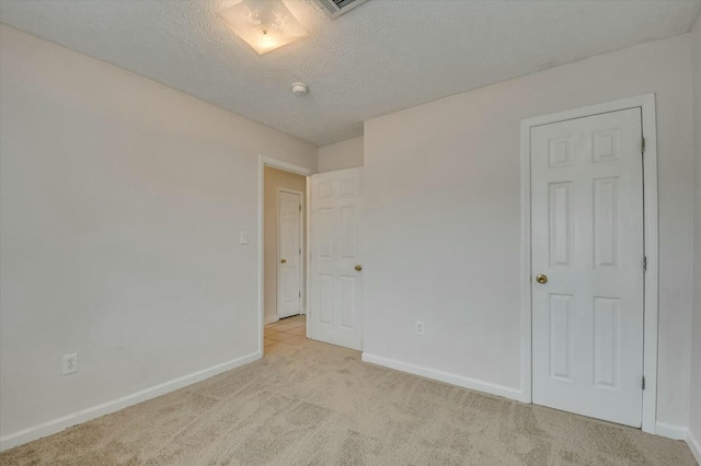 carpeted spare room with a textured ceiling