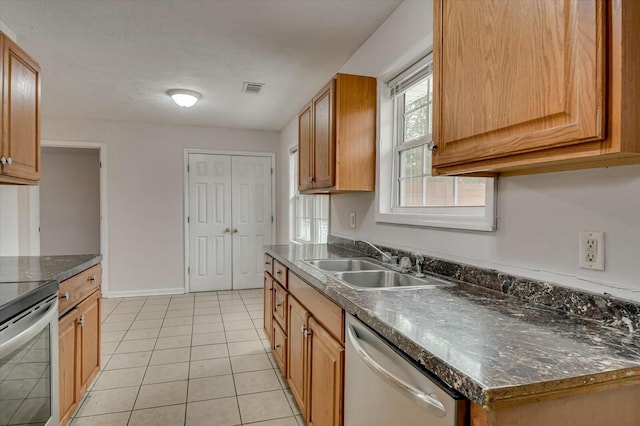 kitchen featuring stainless steel appliances, sink, and light tile patterned floors