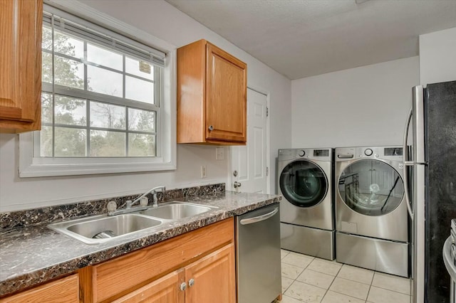 laundry area featuring light tile patterned flooring, sink, and independent washer and dryer