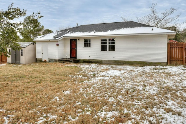 snow covered property with a storage shed and a yard