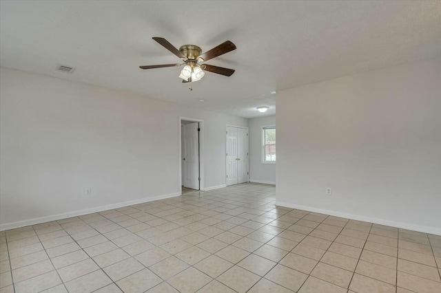 unfurnished room with light tile patterned floors and ceiling fan