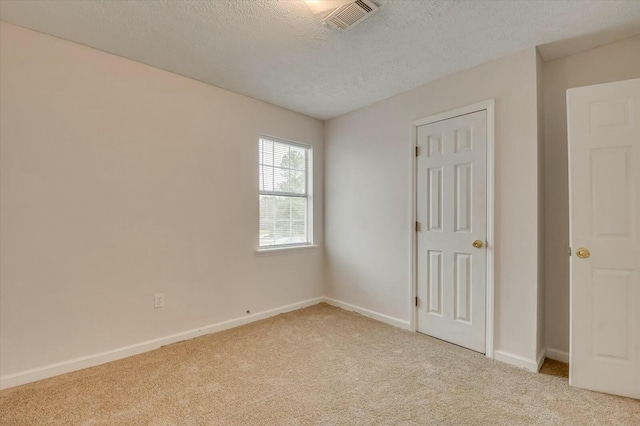 carpeted spare room with a textured ceiling