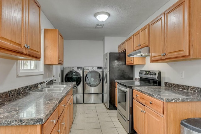 kitchen featuring sink, light tile patterned floors, washer and clothes dryer, appliances with stainless steel finishes, and a textured ceiling