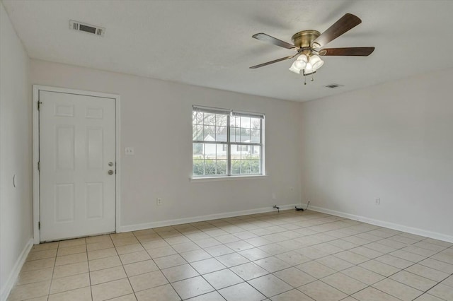 empty room with ceiling fan and light tile patterned floors