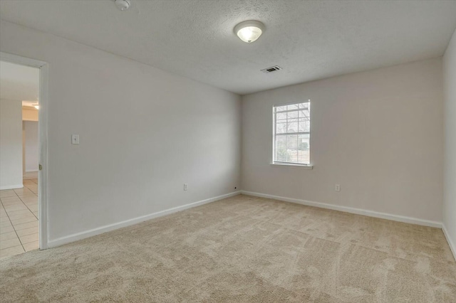 carpeted spare room with a textured ceiling