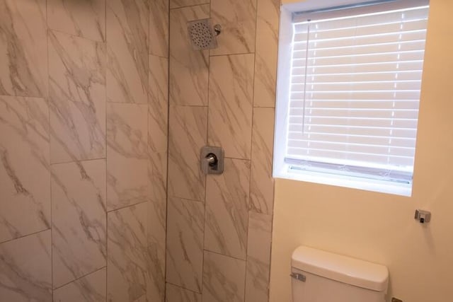 bathroom with toilet and tiled shower