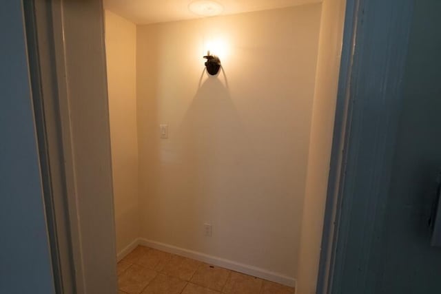 unfurnished room with light tile patterned floors and baseboards