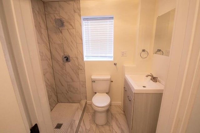 full bathroom with vanity, toilet, baseboards, and a tile shower