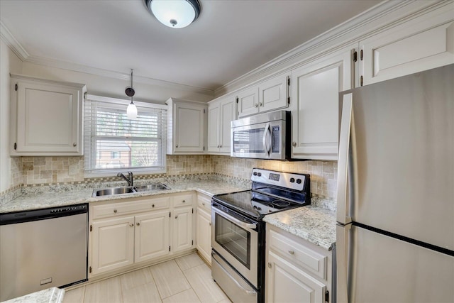 kitchen with decorative backsplash, light stone counters, appliances with stainless steel finishes, ornamental molding, and a sink