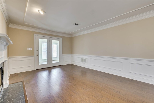 interior space featuring a premium fireplace, visible vents, dark wood-type flooring, and ornamental molding