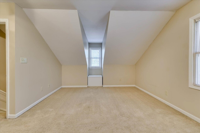 bonus room with light carpet, baseboards, and lofted ceiling