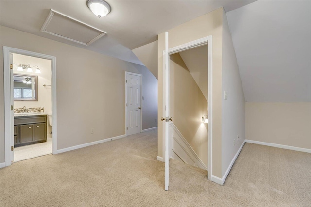 additional living space with light carpet, vaulted ceiling, attic access, and baseboards