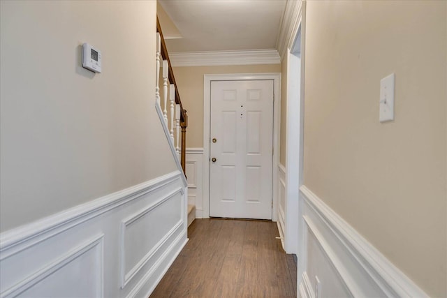 interior space with a wainscoted wall, ornamental molding, dark wood finished floors, and a decorative wall