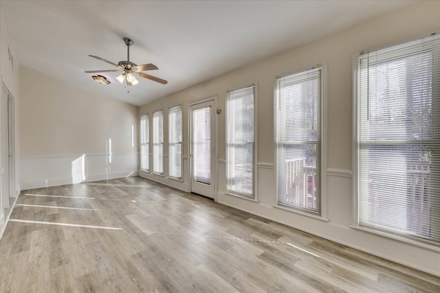 spare room featuring ceiling fan, wood finished floors, and a healthy amount of sunlight