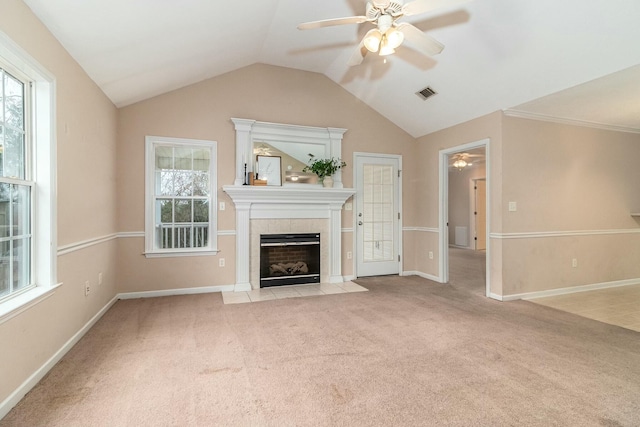 unfurnished living room with lofted ceiling, ceiling fan, ornamental molding, light colored carpet, and a tiled fireplace