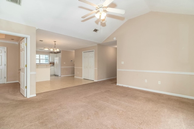 unfurnished living room with crown molding, ceiling fan with notable chandelier, light colored carpet, and vaulted ceiling